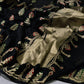 Black Pattu Silk Chanderi saree showing gold woven motifs, green red accents and metallic pallu