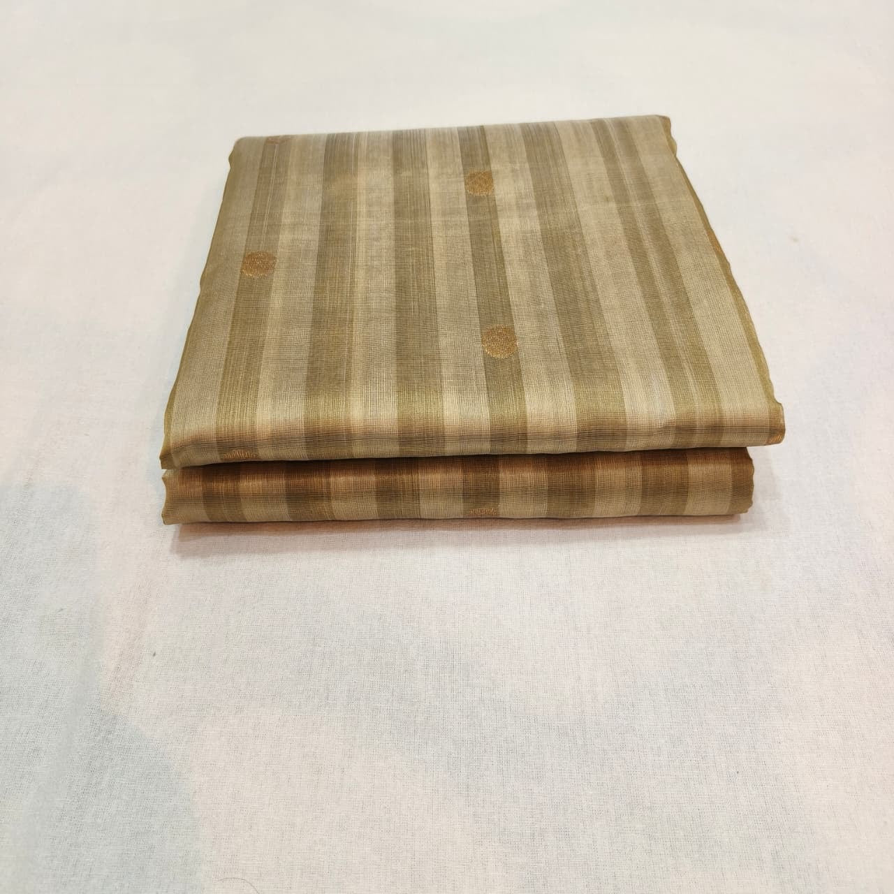 Folded Sandalwood Beige Chanderi saree showing tonal stripes and gold-toned pallu