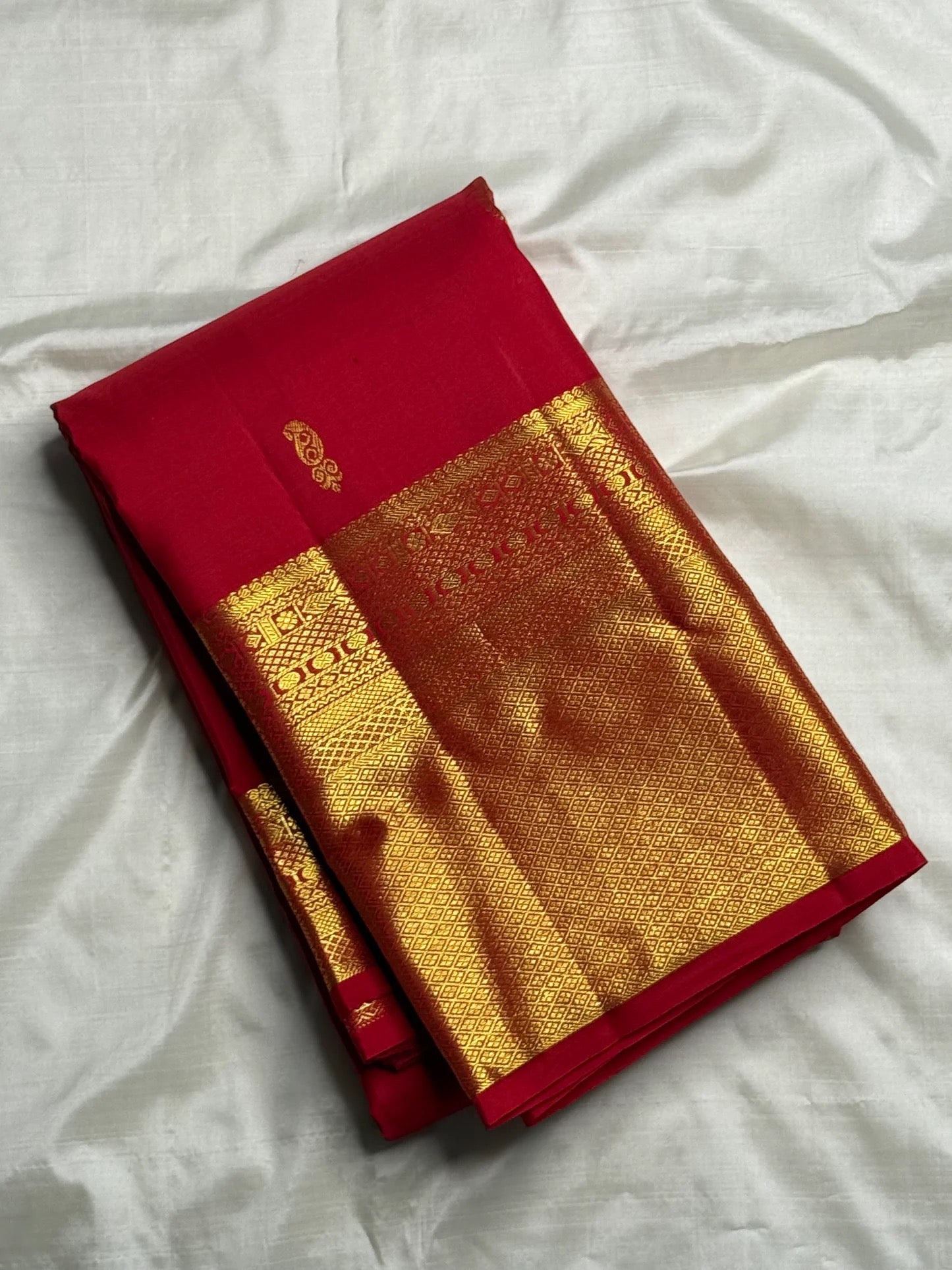 Body detail showing two alternating ornamental gold zari buttas on Pillar-Box Red silk.