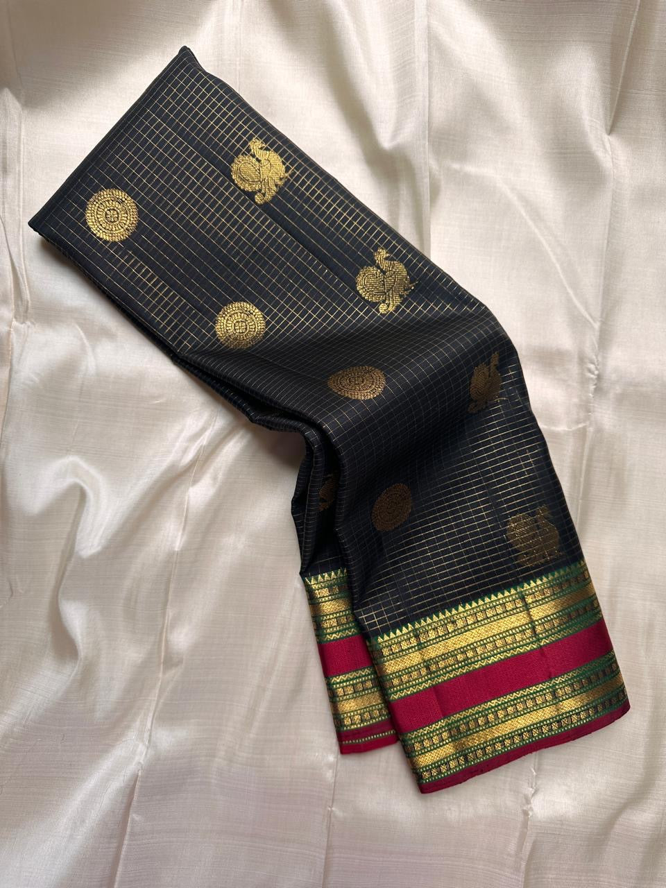 Spread view of maroon pallu with antique gold zari pattern and woven border detailing on Kanchipuram silk saree