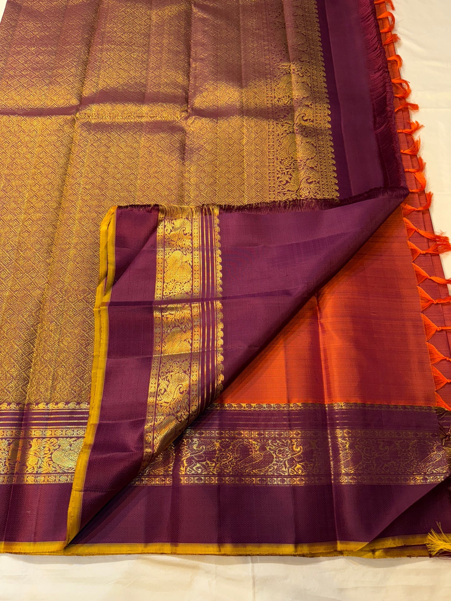 Full spread rust orange Pure Kanchipuram silk saree with round motifs and deep purple zari woven borders, shipped from New Jersey USA
