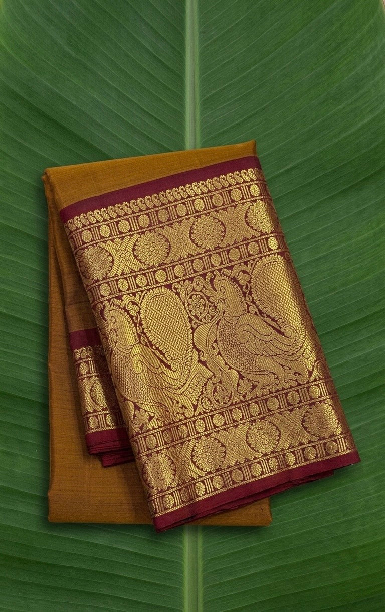 Pure Kanchipuram silk saree in antique gold with Gandaberunda zari border and maroon accents