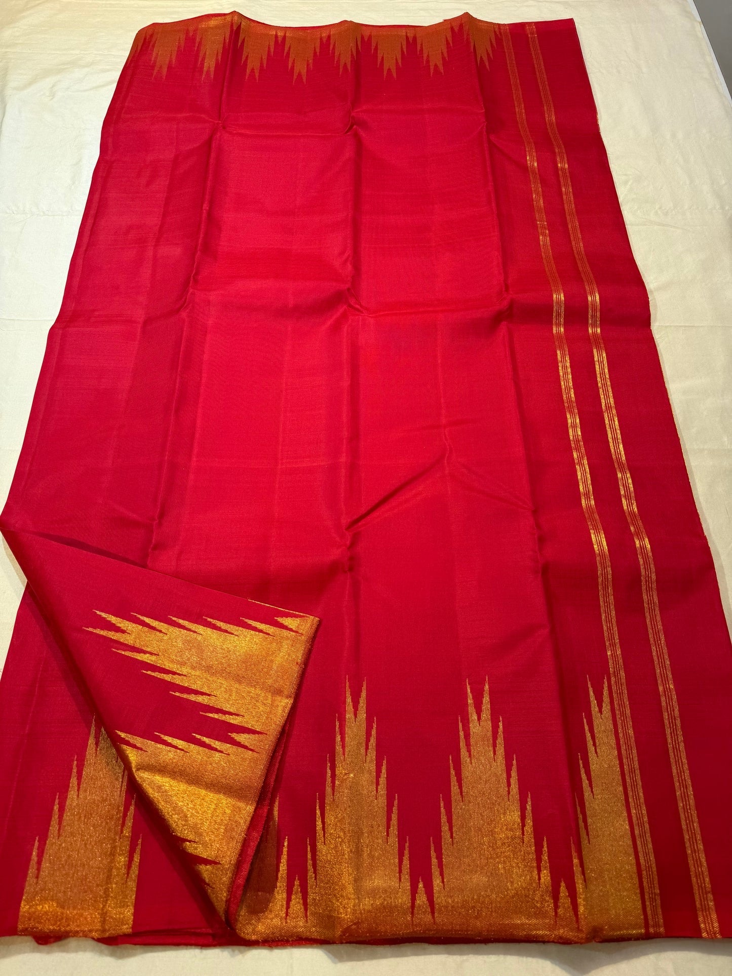 Close-up of ettukol gold zari flames on crimson red Kanchipuram silk saree border — Idam Living
