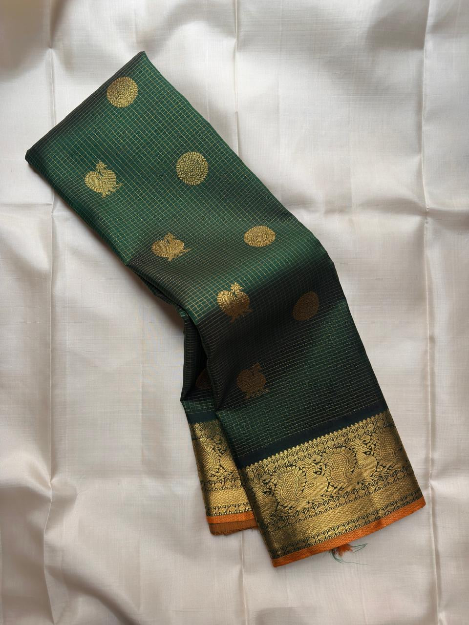 Broad Antique Gold zari Kanchi Pattu border with large peacock-inspired ornamental forms.