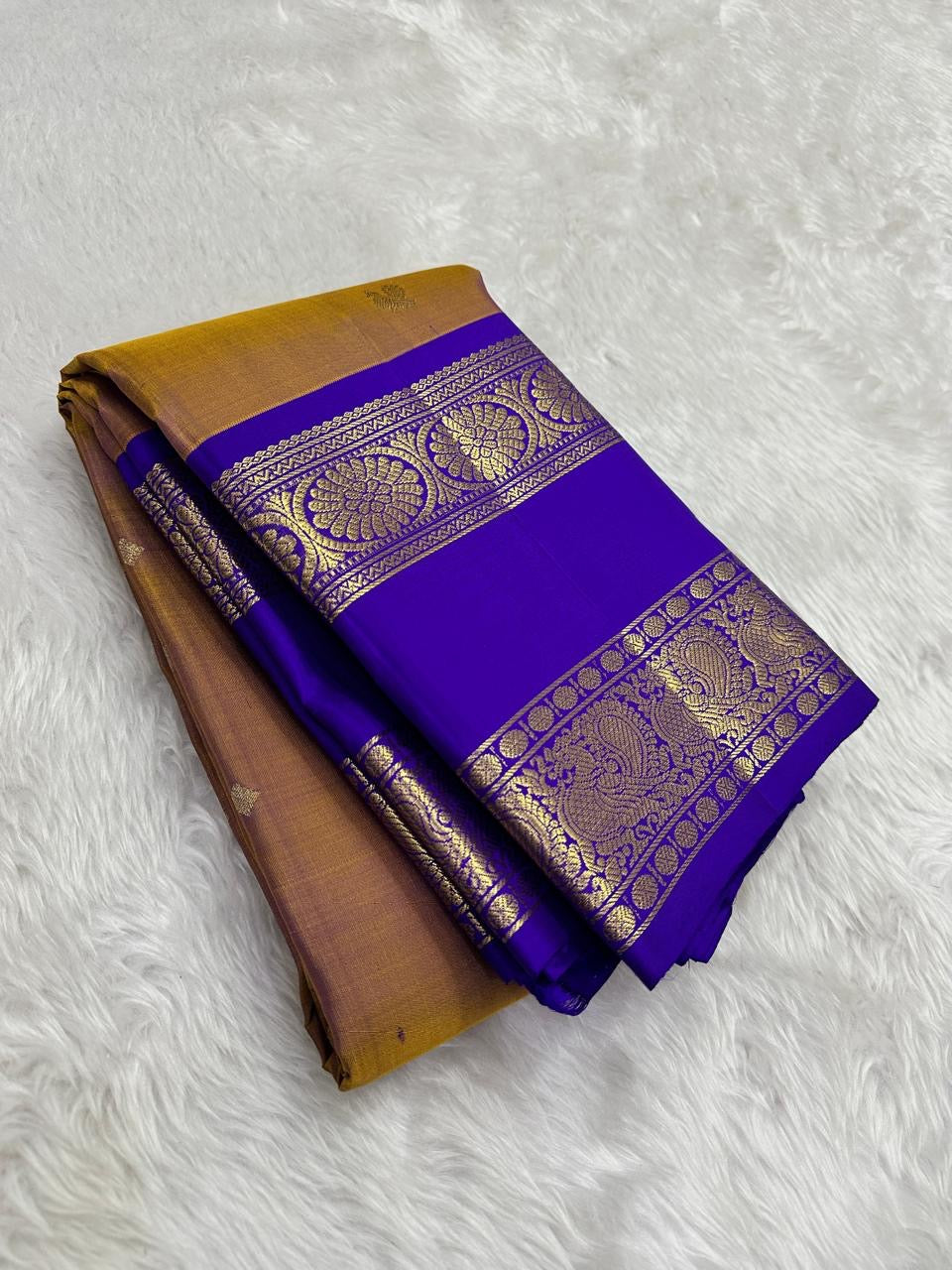 Antique gold pure silk Kanchi saree folded showing royal blue border
