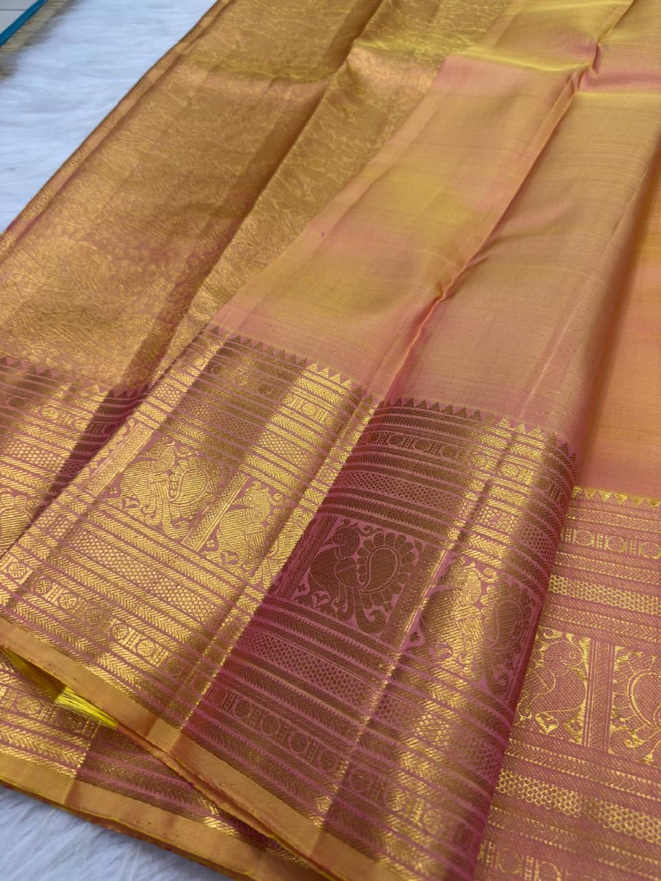 Antique Rose and gold layered zari border on Peach Gold Kanchipuram Butta saree.