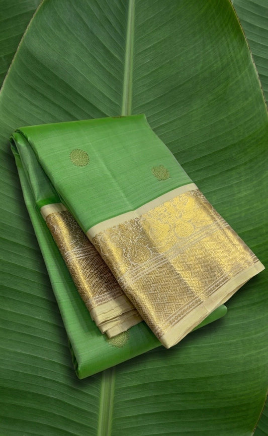 Apple green Kanchipuram silk saree with ivory korvai border and mayil chakram zari butta folded view