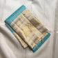 Folded Aqua Blue and Warm Ivory Zari Kattam saree showing intricate gold and silver-toned metallic weaving.