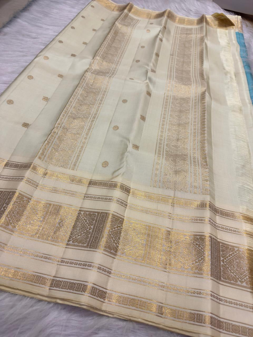 Close view of Aqua Blue Kanchipuram silk showing the zari checked structure and petite woven buttas.