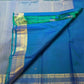 Close-up of scattered zari buttas on a peacock blue KanchiPattu silk saree body