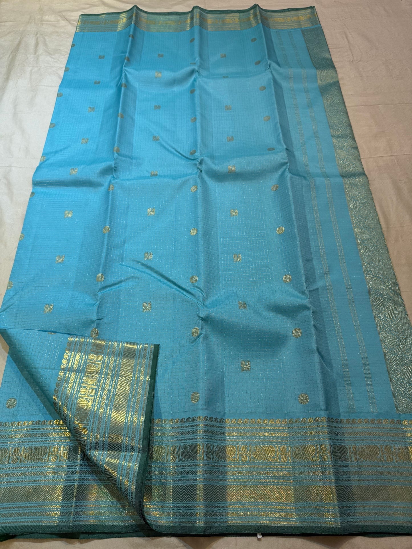 Close-up of gold zari buttas on an aqua blue Kanchipuram Zari Kattam saree