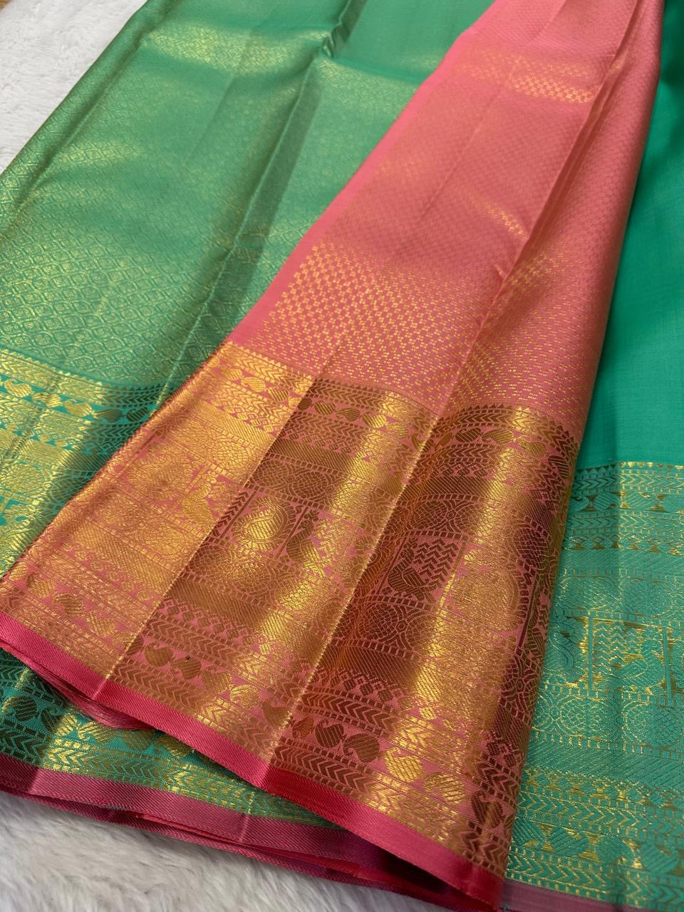 Close-up of gold zari buttas on aqua pure silk Kanchi Pattu saree