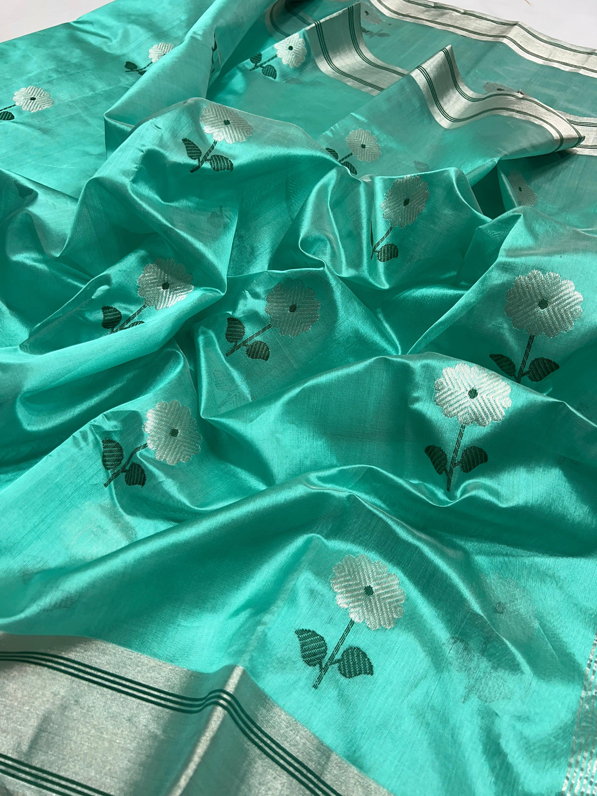 Aqua Turquoise handloom Chanderi silk saree with silver flowers, green leaf accents and luminous silver woven pallu