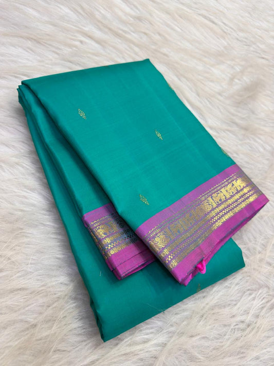 Bright aqua turquoise silk body showing individually spaced small classic-gold zari buttas.