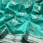 Aqua Turquoise Pattu Silk Chanderi saree with silver floral buttas, deep green leaves and broad silver striped border