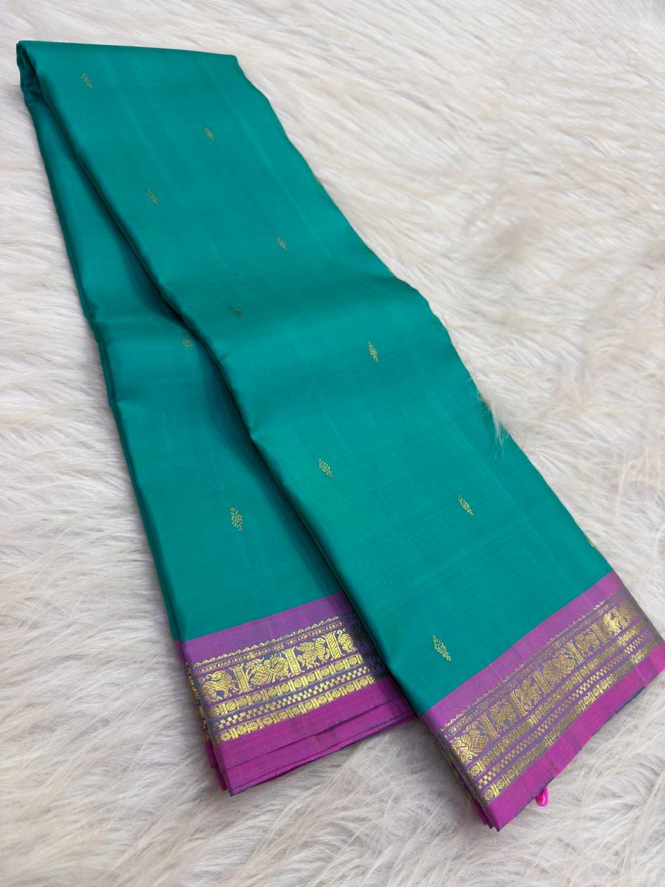 Aqua turquoise Pure Silk Kanjeevaram saree with small gold zari buttas and a vivid Orchid Pink zari border.