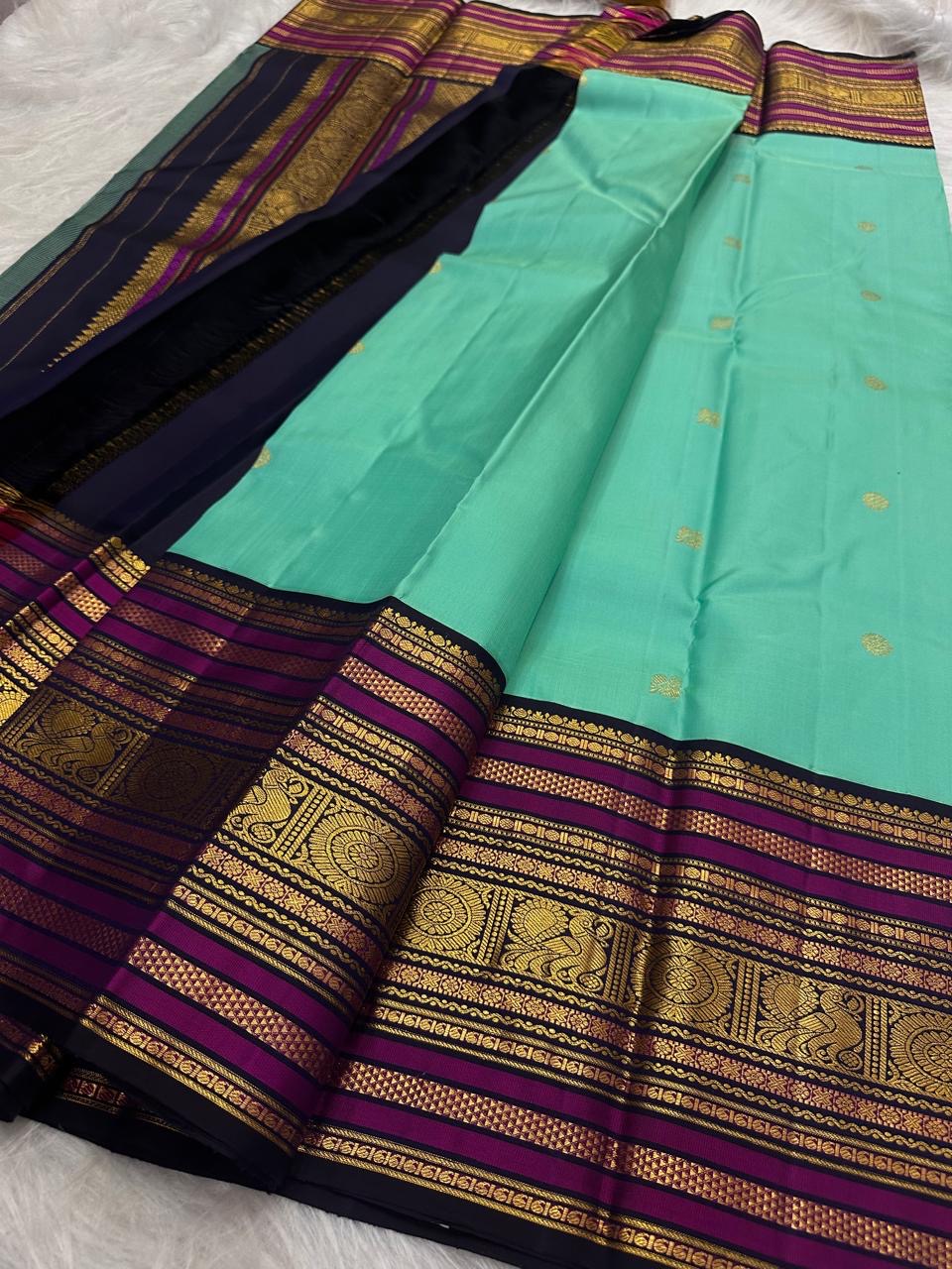 Aqua Turquoise silk body with individually woven gold zari Mayil peacock buttas.