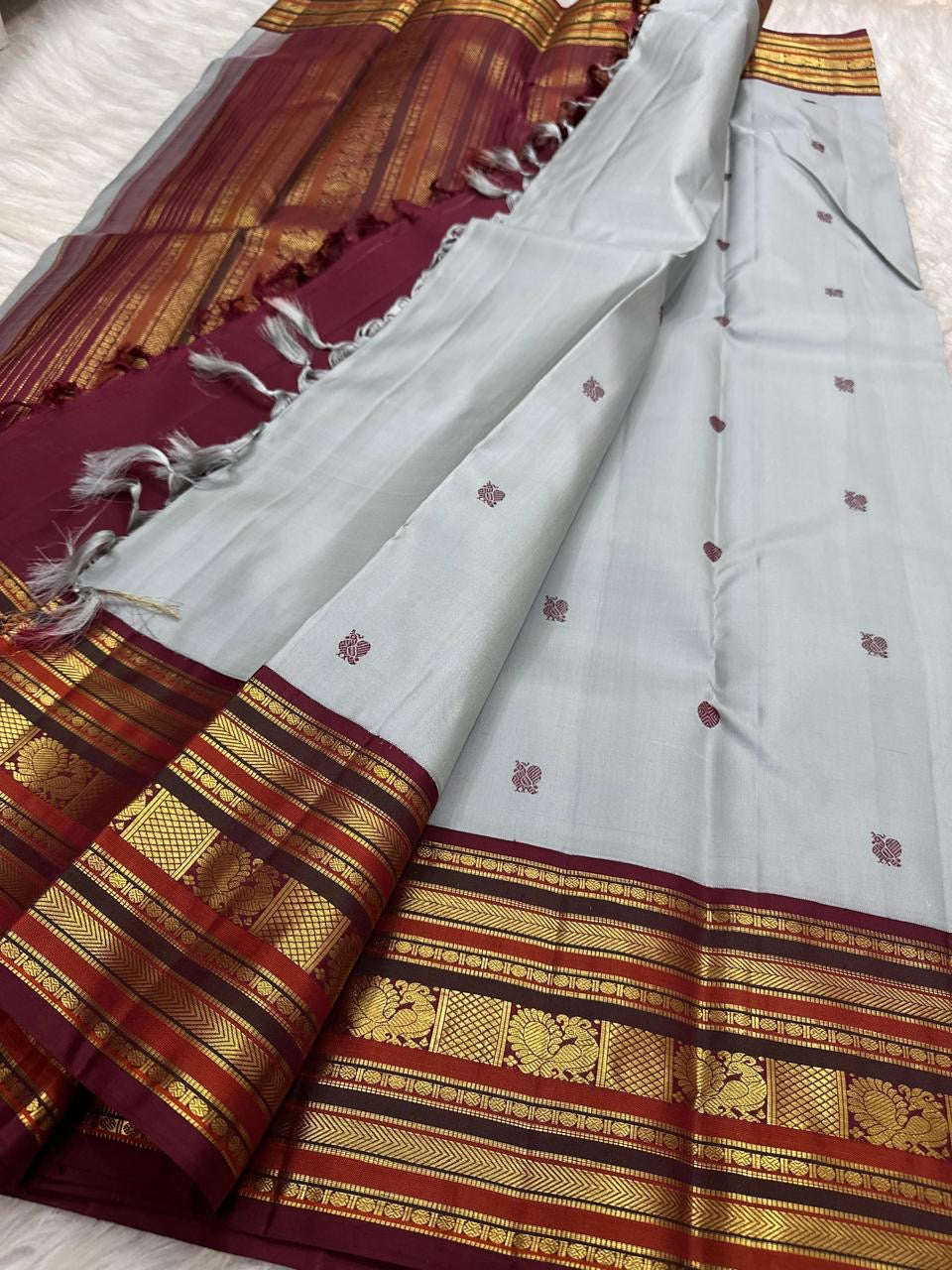 Close view of Kalam paisley buttas on the grey silk body of a Kanchipuram saree