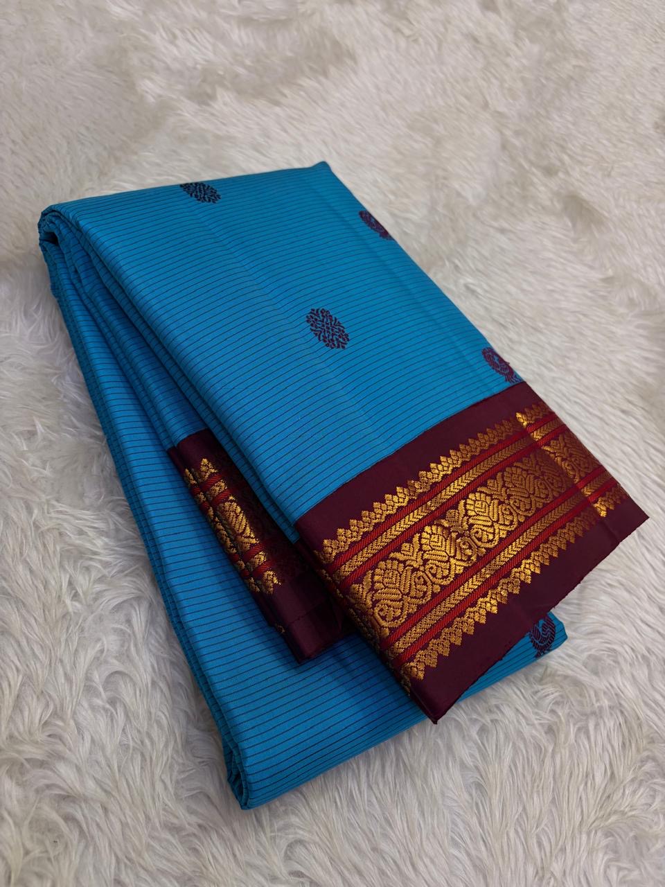 Deep Arakku Kanchipuram pallu with long varisai gold zari registers and repeated ornamental floral motifs.