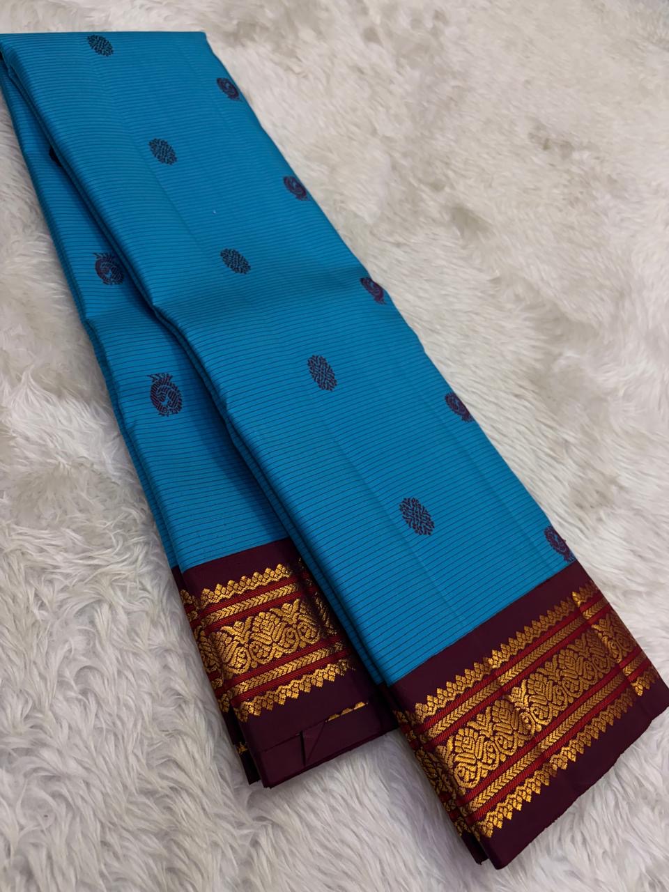 Close view of the hand-interlocked Arakku Korvai pettu with floral-paisley motifs in classic gold zari.