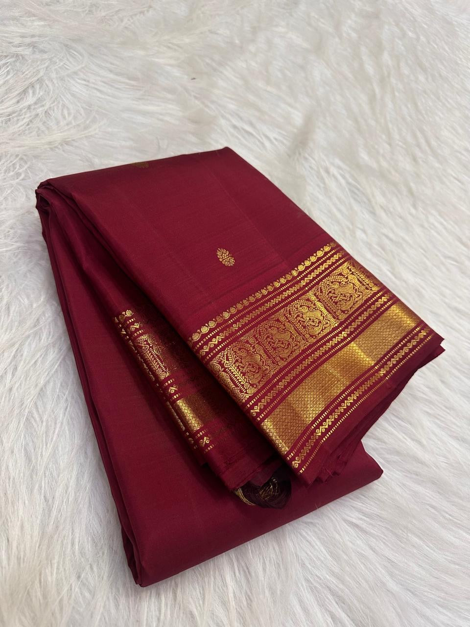 Handwoven Burgundy Kanchipuram saree with ornate Poo-Kodi Jaal and luminous gold border