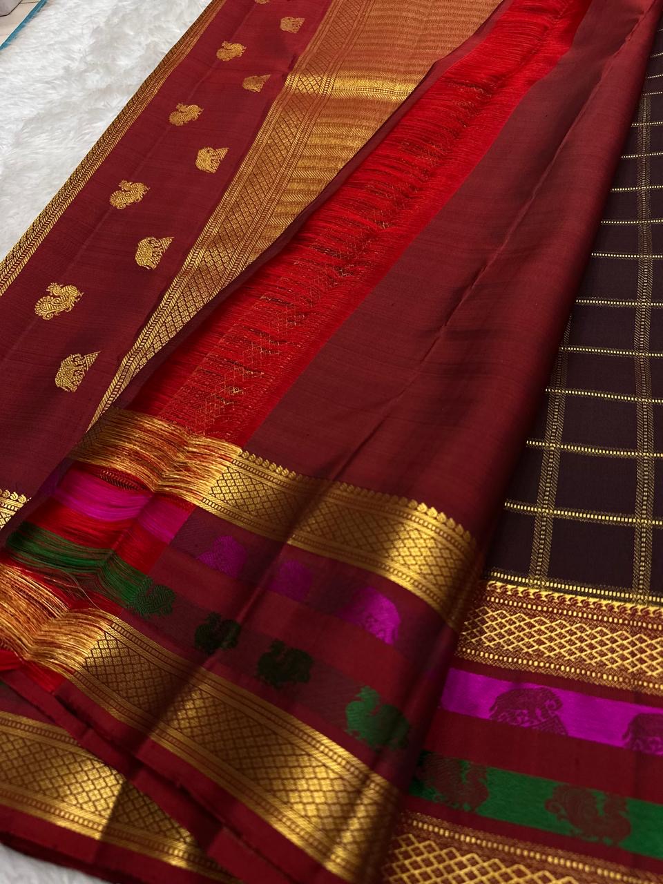 Arakku-maroon Kanchipuram border with Rani Pink Yaanai motifs framed by warm classic gold zari lattice.