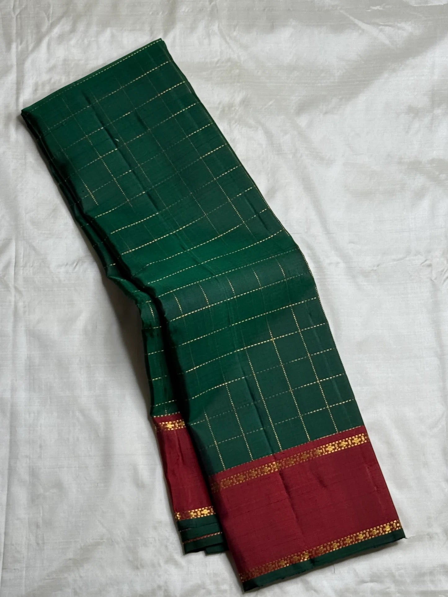 Close view of the Arakku Red border with narrow gold zari bands and green finishing edge