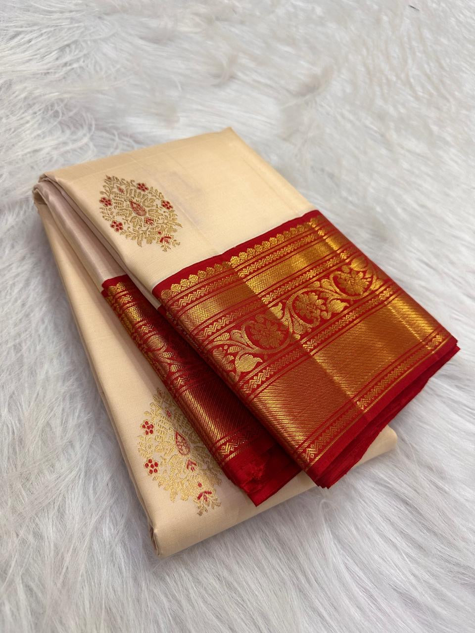 Arakku red Kanjivaram border with broad gold zari floral scrolls beside the warm ivory body.