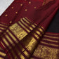 Deep brown purple handwoven Kanchipuram saree with rich red and gold traditional Varisaipet border.