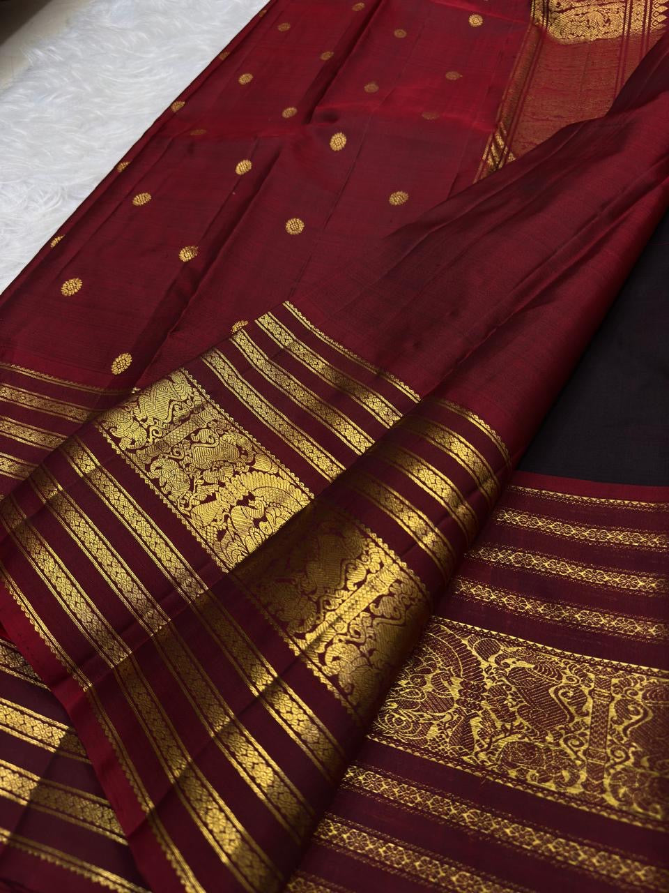Deep brown purple handwoven Kanchipuram saree with rich red and gold traditional Varisaipet border.
