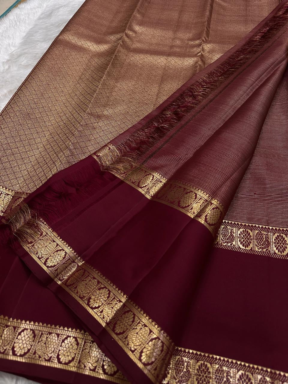 Arakku red silk body showing close rhythmic rows of tiny traditional gold zari flower buttas across the field.