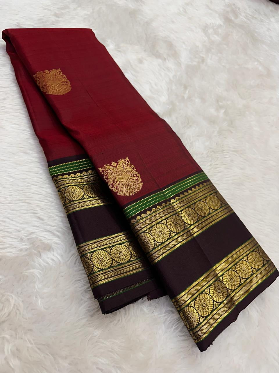 Handwoven pure silk Kanjivaram rettapet saree in arakku red with larger gold buttas and a coffee-brown contrast border.
