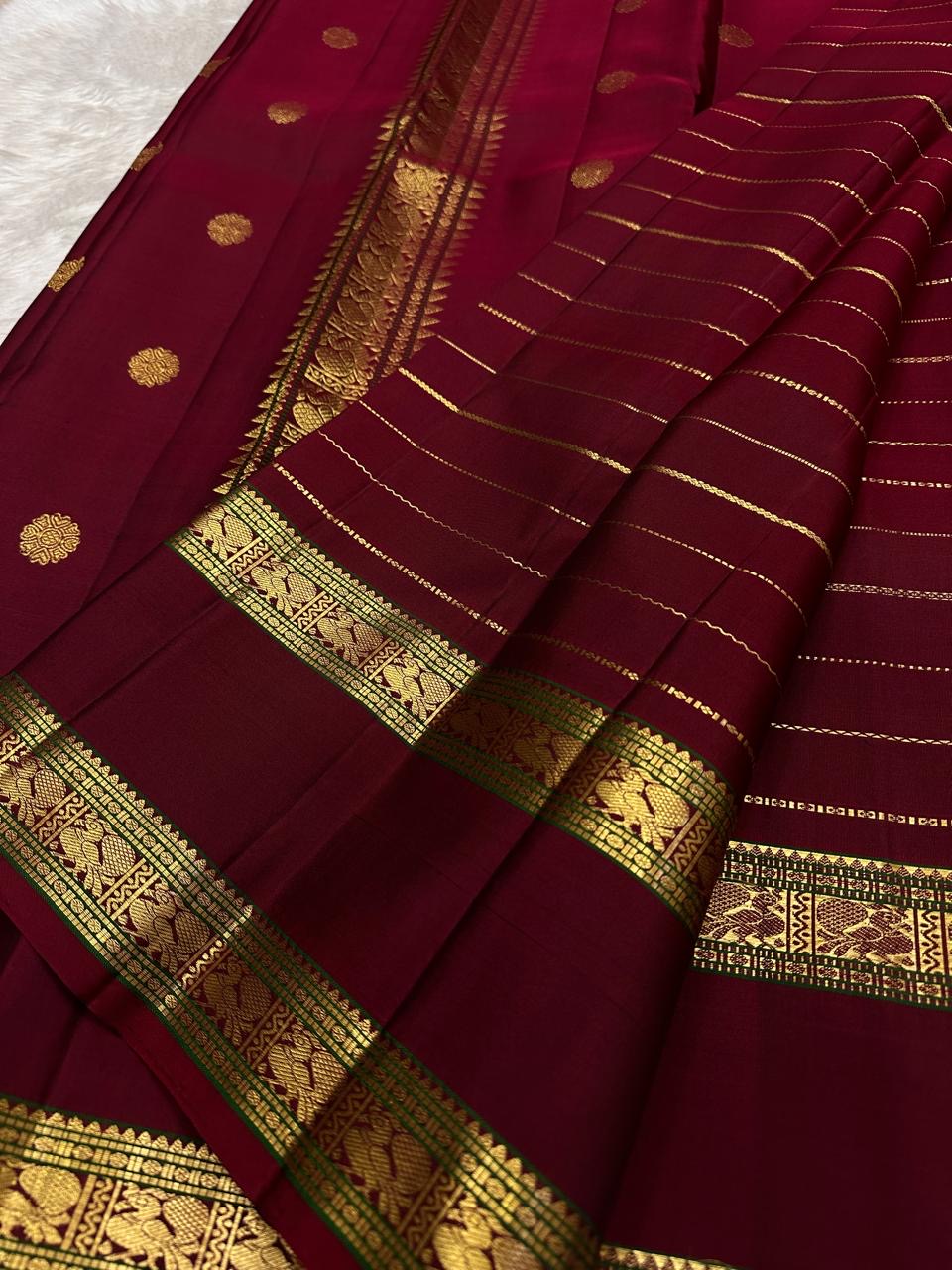 Vintage-style Deep Arakku Red Rettapet saree with traditional Mayil gold zari border.