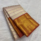 Burnt terra-cotta border with peacocks and Pavun coin motifs, warm-ivory Kanjipuram saree