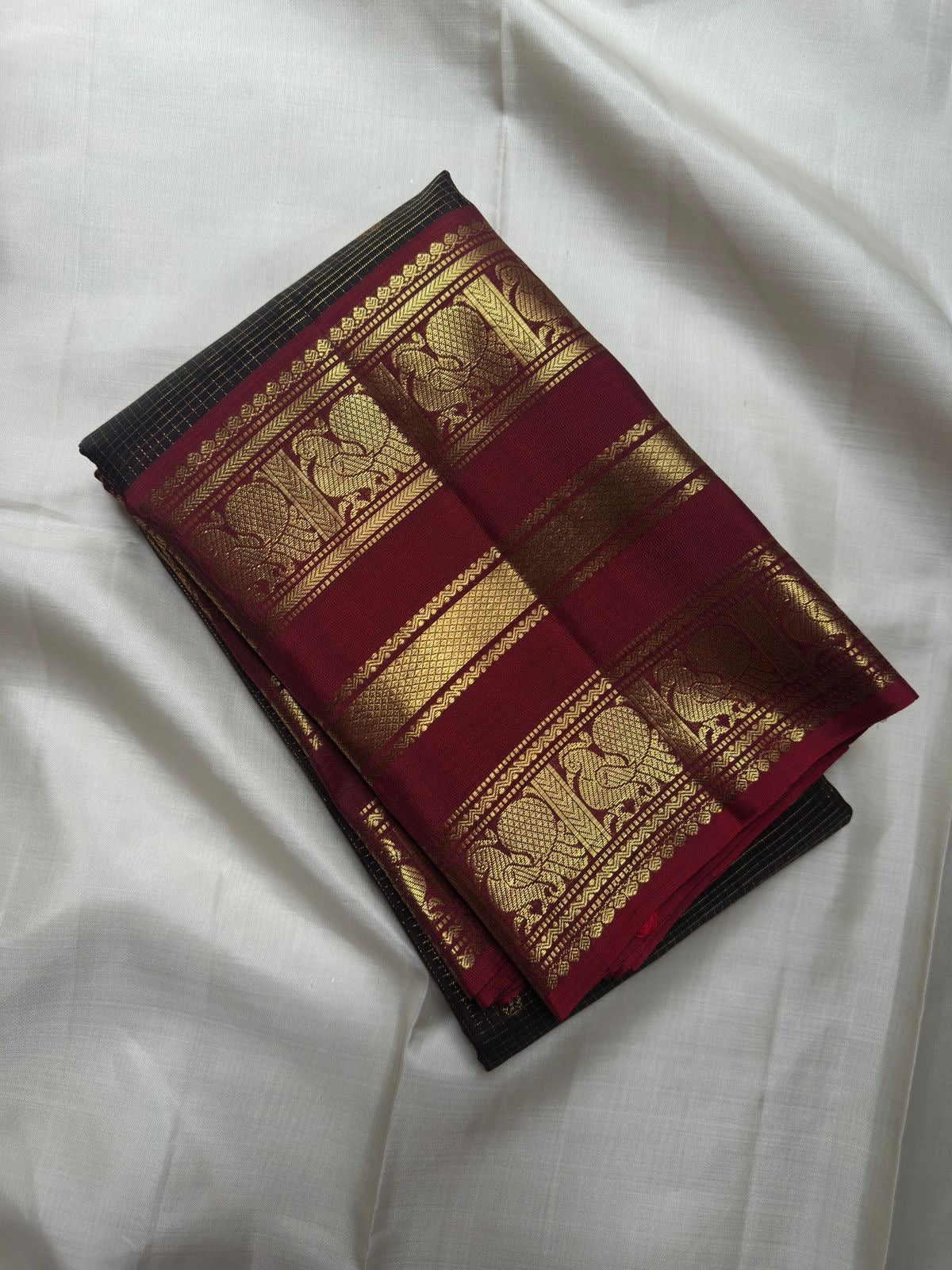 Deep Coffee Brown Pure Silk body with petite zari buttas and broad traditional peacock gold zari border.