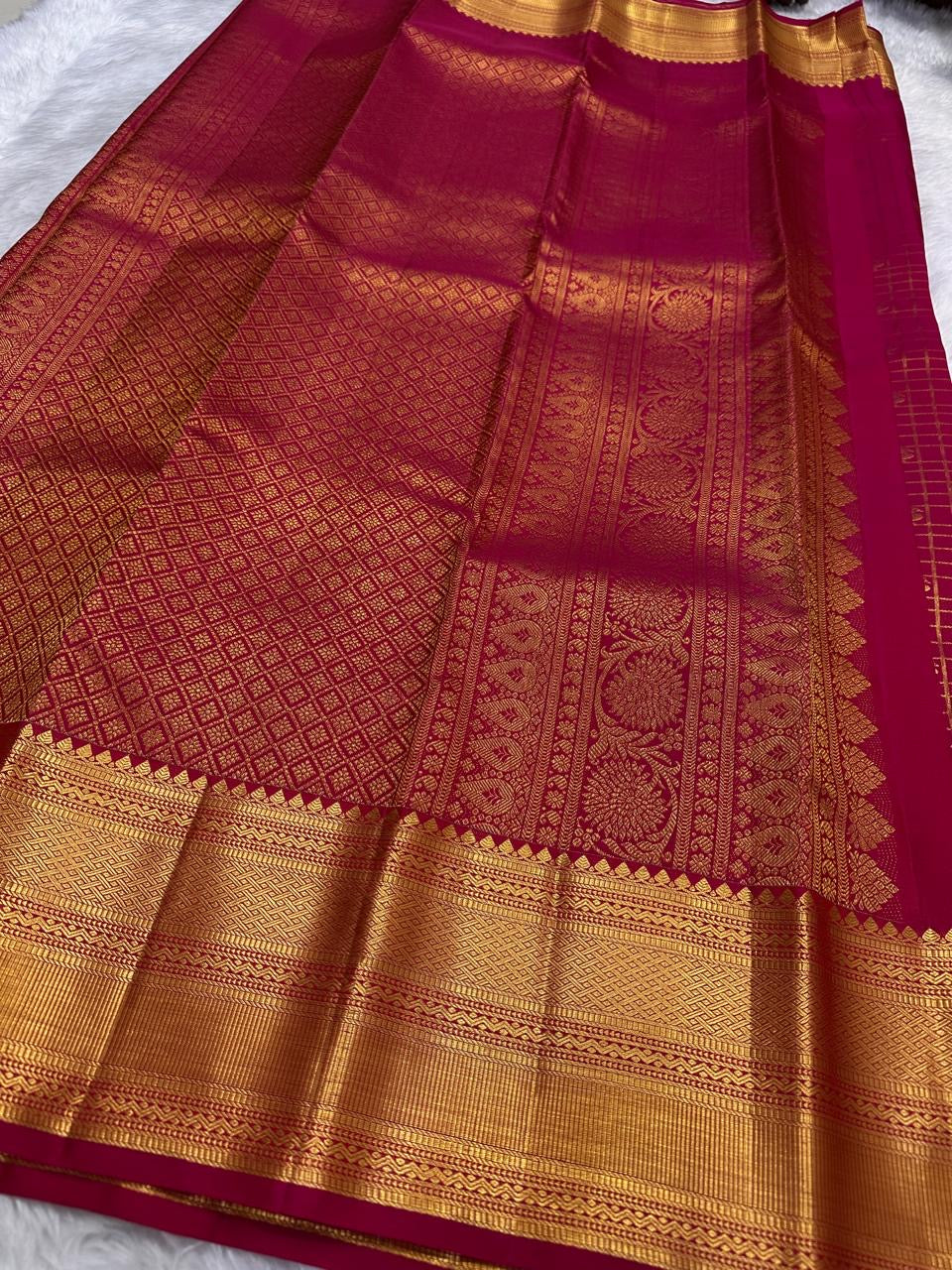 Folded view of arakku red pure silk Kanjeevaram saree with Zari Kattam Gandaberunda Butta
