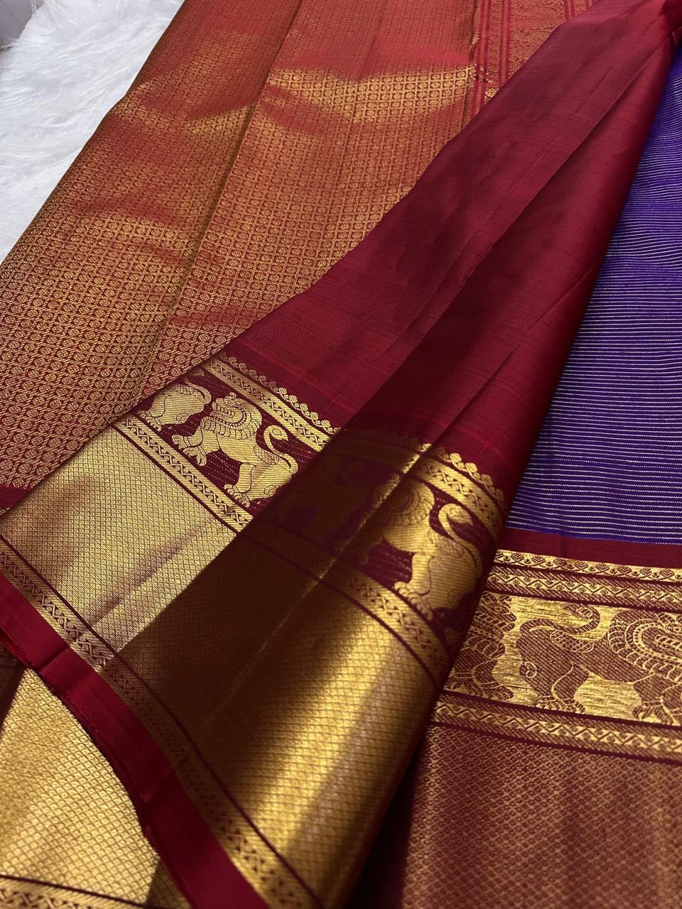 Detailed Arakku Red Kanchipuram pallu with dense geometric gold zari field and ornamental woven registers.