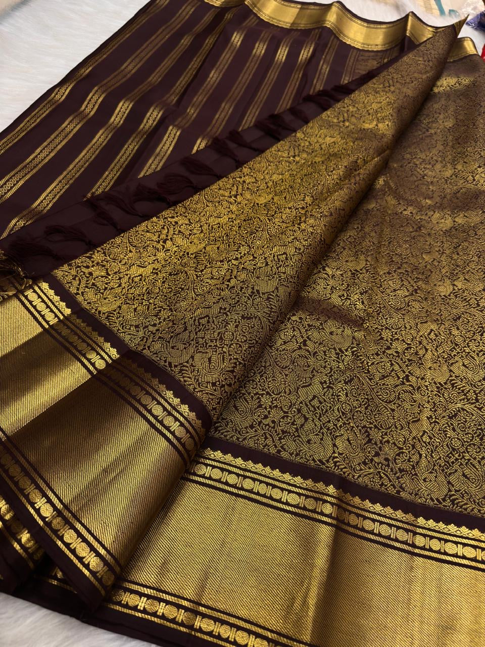 Deep brown silk body detail showing elegant vertical gold zari lines.