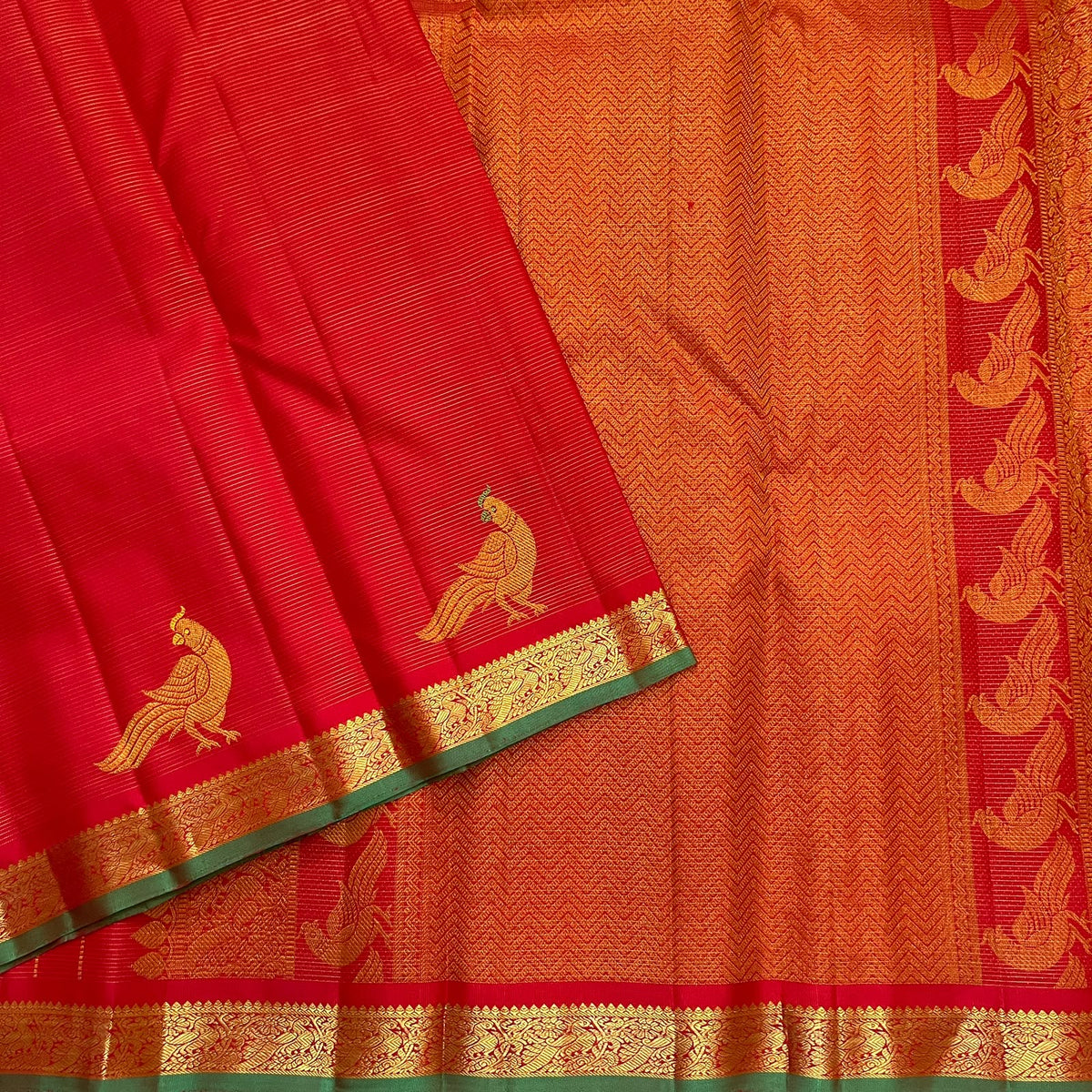 Warm gold zigzag seer pallu with Kili bird motifs on a vermilion red pure silk Kancheepuram saree