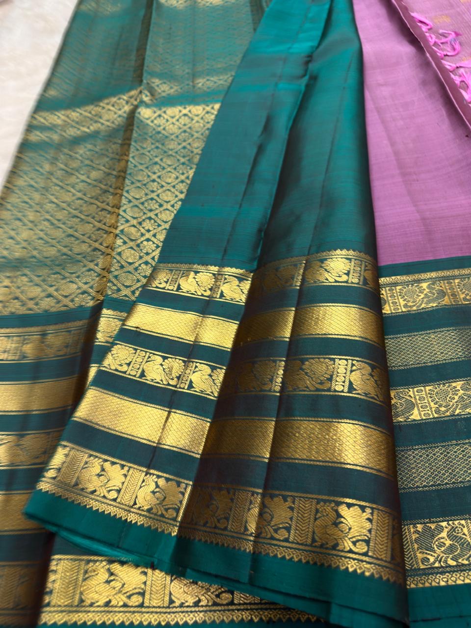 Peacock green Varisaipet border with gold zari floral and peacock registers on a lavender Kanjivaram saree