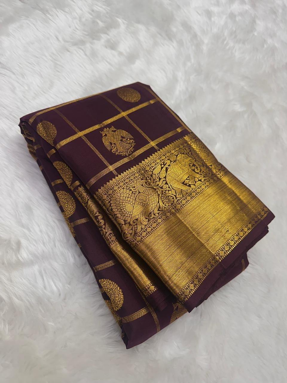 Grand antique gold zari pallu of deep aubergine Zari Kattam Kanchipuram silk saree with densely woven geometric ornamental detailing.