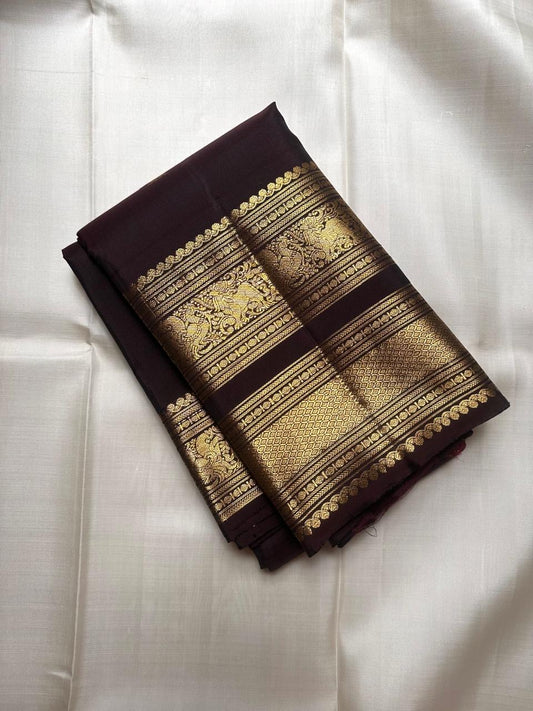 Close-up of gold zari buttas on Aubergine Kanjivaram silk saree body