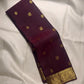 Deep aubergine Kanjivaram saree showing ornate antique gold zari Mayil motif border