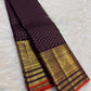 Close view of antique-gold traditional zari border on Deep Brown silk with purple Kanchana undertone.
