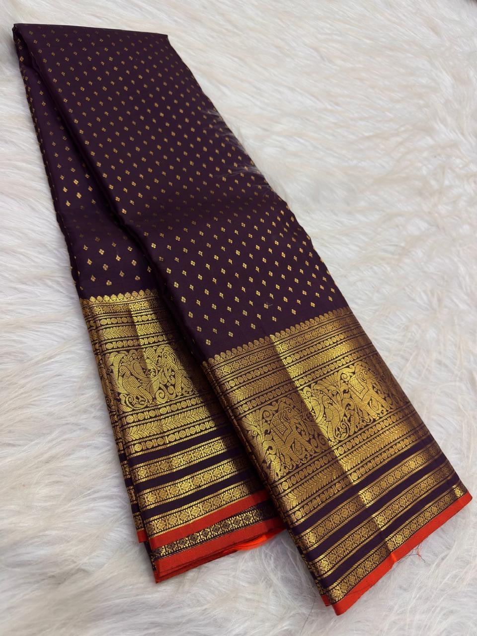 Close view of antique-gold traditional zari border on Deep Brown silk with purple Kanchana undertone.