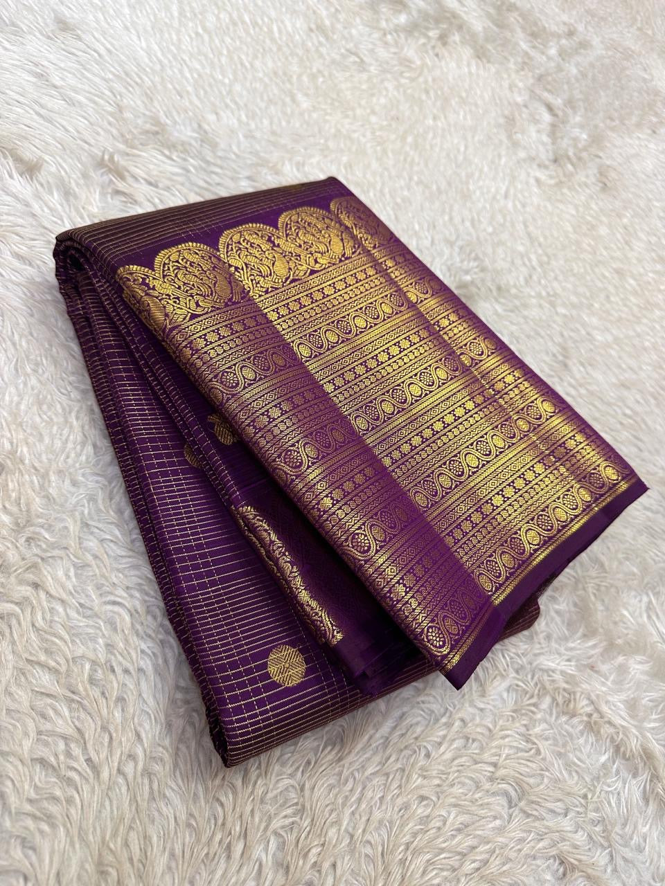 Deep Aubergine Purple Pure Silk Kanchipuram Zari Kattam saree with gold buttas, broad ornate zari border and tasselled pallu.