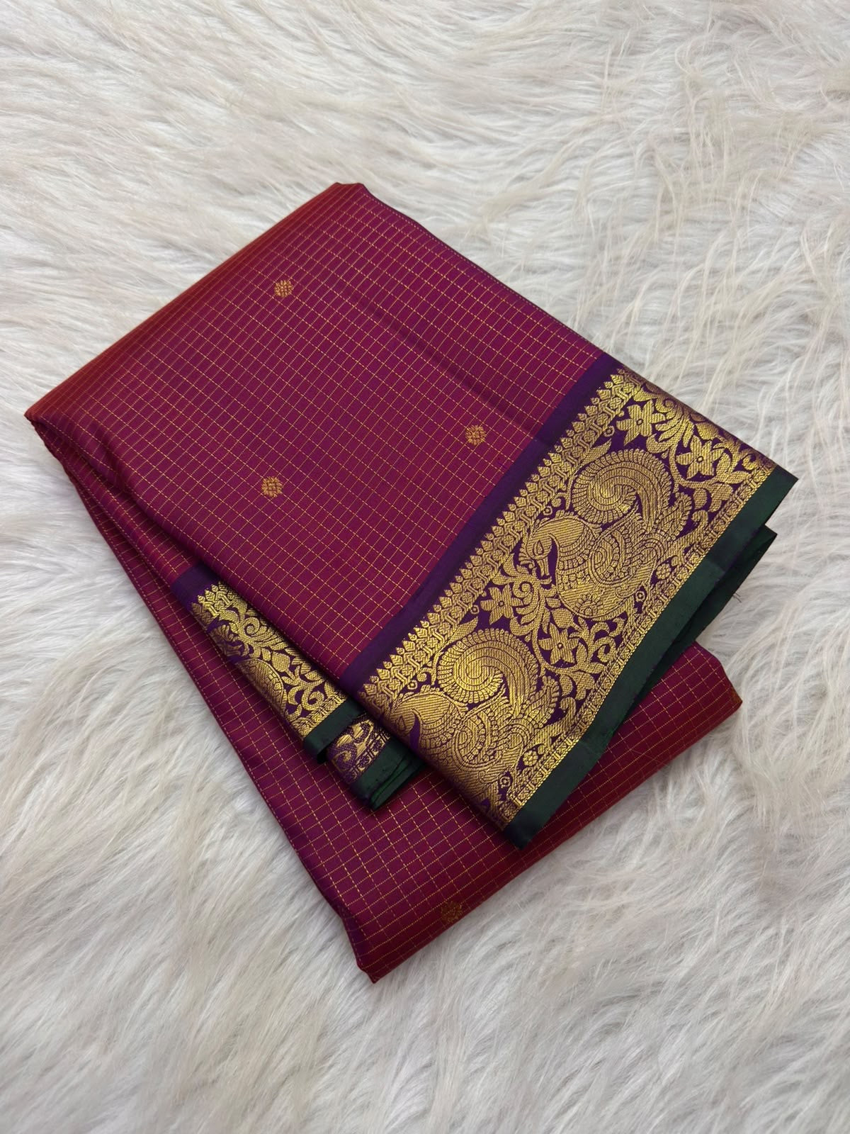 Pallu moving from aubergine-plum into burnished gold with dense floral zari lattice on raspberry red Kanchipuram saree