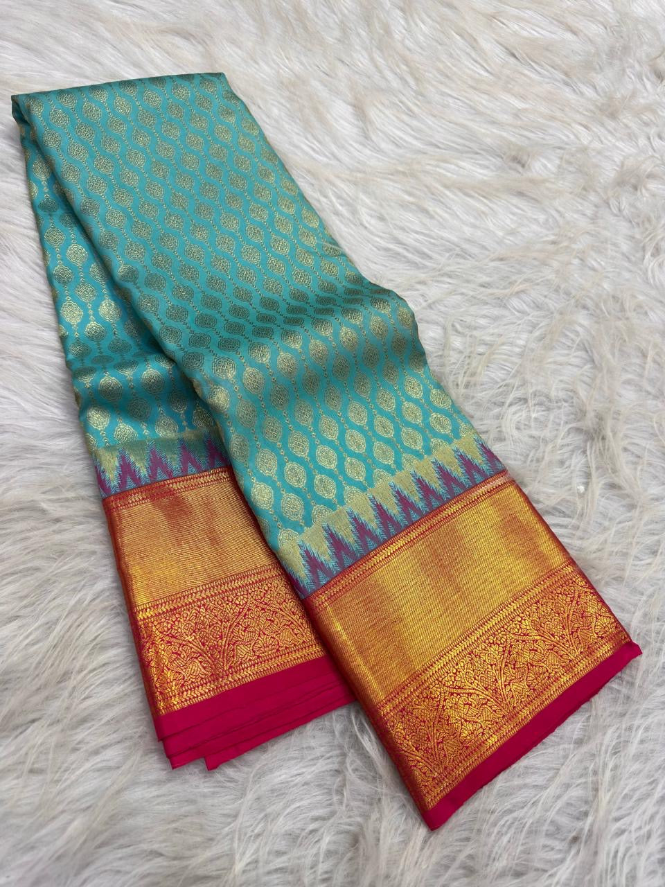 Handwoven pure silk Kanchipuram butta saree in turquoise blue with fuchsia pink contrast and gold buttas.