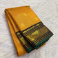 Turmeric yellow Kanchi Pattu with vertical Vairaoosi lines, gold buttas and black Kai Korvai Kamalam border with green edging.