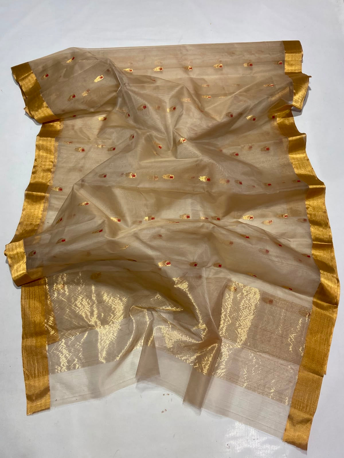 Close-up of Sandalwood Beige Katan Silk Chanderi saree showing petite gold buttas with vermilion-red accents.